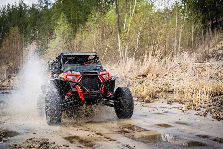 A UTV heads down a trail.